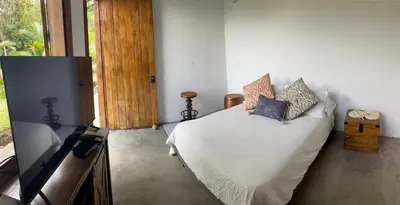 a bedroom with a bed with white sheets and pillows at Quinta San Felipe in Manizales