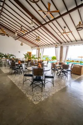 a dining room with tables and chairs and windows at Quinta San Felipe in Manizales