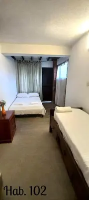 a bedroom with two beds and a dresser at Villa Tikuna in Mariquita