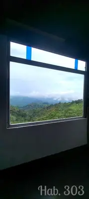 a window on a train looking out at the mountains at Villa Tikuna in Mariquita
