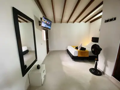 a bedroom with a bed and a large mirror at Aparta Suites Rosales in Medellín