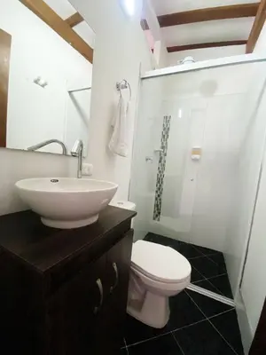 a bathroom with a white sink and a toilet at Aparta Suites Rosales in Medellín