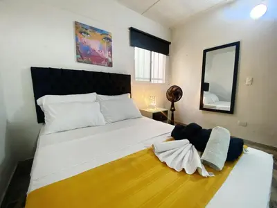 a bedroom with a large white bed and a mirror at Aparta Suites Rosales in Medellín