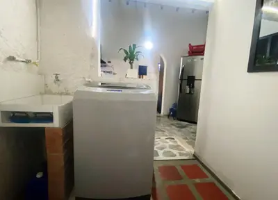 a bathroom with a white refrigerator and a sink at Aparta Suites Rosales in Medellín