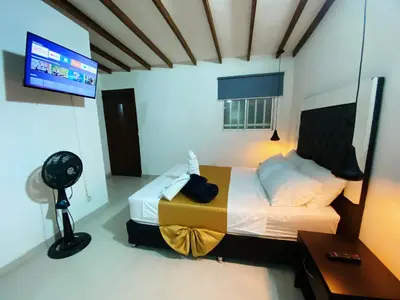 a bedroom with a bed and a flat screen tv at Aparta Suites Rosales in Medellín