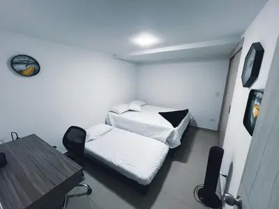 a room with two beds and a table in it at Medellin's Coolest neighborhood in Medellín