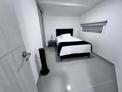 a bedroom with a bed in a white room at Medellin's Coolest neighborhood in Medellín
