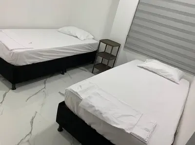 a bedroom with two beds and a chair in it at Apartamento de descanso in La Dorada