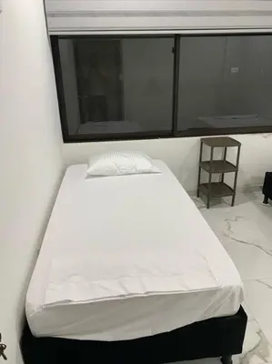 a white bed in a room with a window at Apartamento de descanso in La Dorada