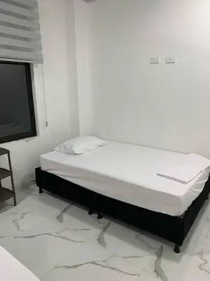 a bed sitting in a room with a tv at Apartamento de descanso in La Dorada
