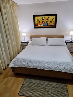 a bedroom with a bed with two night stands and two lamps at HOTEL GALICIA PLAZA in Manizales