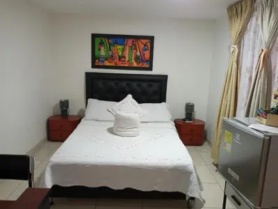 a bedroom with a bed with a white bedspread at HOTEL GALICIA PLAZA in Manizales