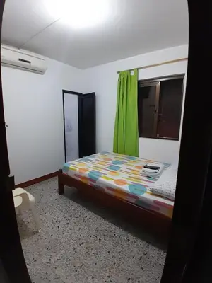 a bed in a room with a green curtain at Hotel Bruselas Mutata in Mutatá