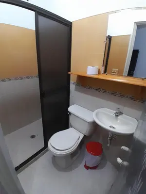 a bathroom with a toilet and a sink and a mirror at Hotel Bruselas Mutata in Mutatá