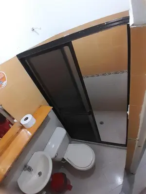 a bathroom with a toilet and a glass shower stall at Hotel Bruselas Mutata in Mutatá