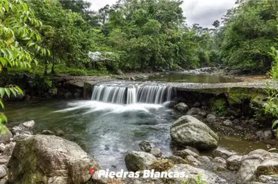 a waterfall in the middle of a river with rocks at Hotel Bruselas Mutata in Mutatá