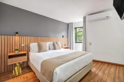 a bedroom with a large bed and a window at Apartamento de lujo laureles con Aire y hamaca 200 in Medellín