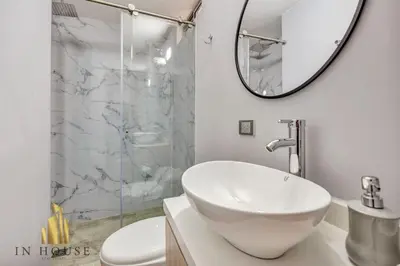 a white bathroom with a sink and a shower at Apartamento de lujo laureles con Aire y hamaca 200 in Medellín