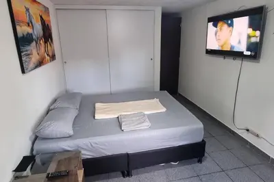 a bedroom with a bed with a tv on the wall at hermosa casa para tour comuna 13 in Medellín