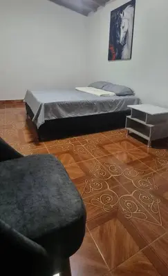 a bedroom with a bed and a chair in a room at hermosa casa para tour comuna 13 in Medellín