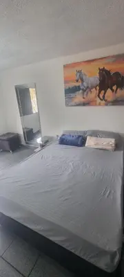 a bed in a room with a painting of horses on the wall at hermosa casa para tour comuna 13 in Medellín