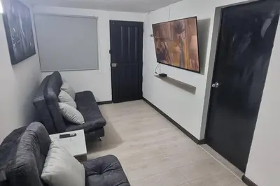 a living room with two couches and a black door at hermosa casa para tour comuna 13 in Medellín