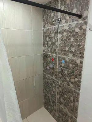 a shower with a stone wall in a bathroom at Hotel Confort Boutique in Rionegro
