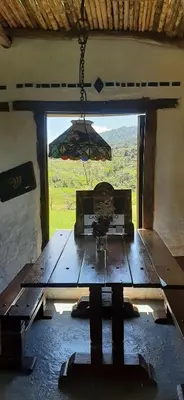 a wooden table in a room with a large window at Hoguera del Nómada in Santo Domingo