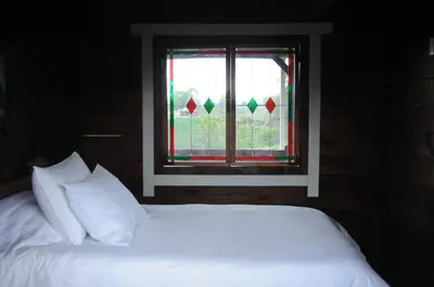 a bedroom with a bed and a window with christmas decorations at Hoguera del Nómada in Santo Domingo
