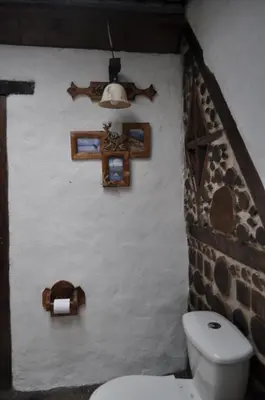 a bathroom with a toilet and a cross on a wall at Hoguera del Nómada in Santo Domingo
