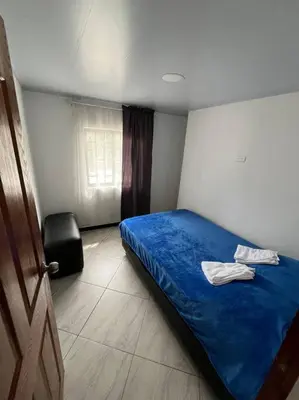 a bedroom with a blue bed and a chair at Apartamento Dcastańo in Medellín