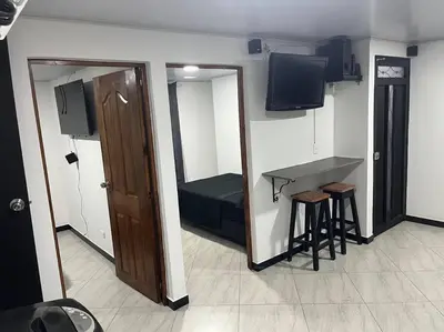 a small room with a bed and a table and stool at Apartamento Dcastańo in Medellín