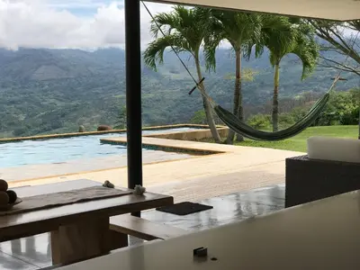 a room with a hammock and a swimming pool at Finca Los Polines en Tarso in Tarso