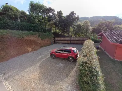 a red car parked on the side of a road at loft grupo y parejas AZUCENAS in Jardin