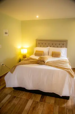 a bedroom with a large white bed with two pillows at loft grupo y parejas AZUCENAS in Jardin
