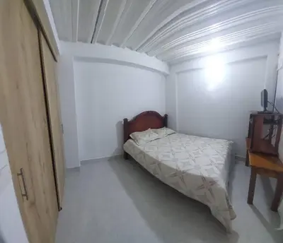 a small bedroom with a bed and a table at Casa de descanso unifamiliar in Venecia