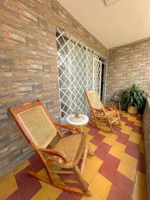two rocking chairs and a table on a patio at Coliving Casa encanto, Apartamento - Habitaciones, Laureles-América in Medellín