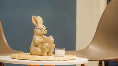 a statue of a rabbit with glasses sitting on a table with a candle at Coliving Casa encanto, Apartamento - Habitaciones, Laureles-América in Medellín