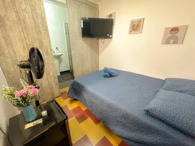 a bedroom with a blue bed and a tv at Coliving Casa encanto, Apartamento - Habitaciones, Laureles-América in Medellín