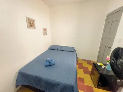 a small room with a bed with a blue blanket at Coliving Casa encanto, Apartamento - Habitaciones, Laureles-América in Medellín