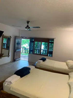 a bedroom with three beds and a ceiling fan at Hotel Tekal del Rio in Puerto Boyacá