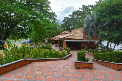 a house with a brick walkway in a garden at Hotel Tekal del Rio in Puerto Boyacá