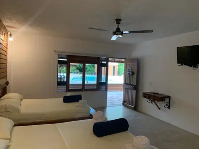 a bedroom with two beds and a flat screen tv at Hotel Tekal del Rio in Puerto Boyacá