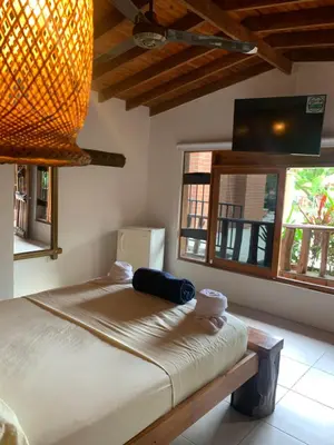 a bedroom with a bed in a room with windows at Hotel Tekal del Rio in Puerto Boyacá