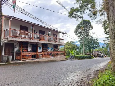 a house with a balcony on the side of a road at Casa familiar vacacional in Jardin
