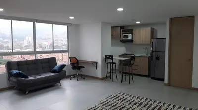 a living room with a couch and a kitchen at Confortable Aparta Loft 903 Aiana Verde in Medellín