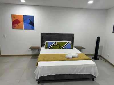 a bedroom with a large bed in a white room at Confortable Aparta Loft 903 Aiana Verde in Medellín