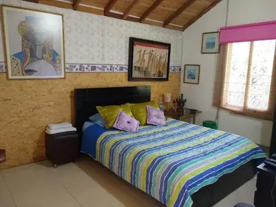 a bedroom with a bed with two pillows on it at Hospedaje Santaelena -chalets de montaña- in Santa Elena