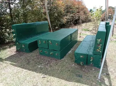 a group of green benches sitting on the grass at Hospedaje Santaelena -chalets de montaña- in Santa Elena
