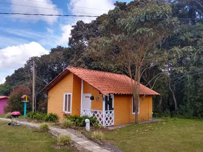 a small yellow house with a red roof at Hospedaje Santaelena -chalets de montaña- in Santa Elena